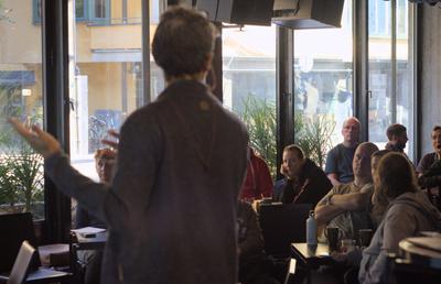 Ismael gesturing while presenting, seen from behind