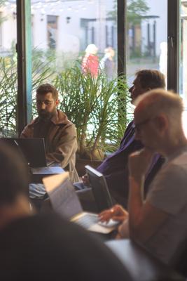 Attendees watching a talk by the windows
