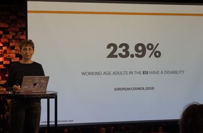 Carme presenting a slide with the statistic '23.9%'