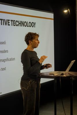 Carme presenting a slide on assistive technology